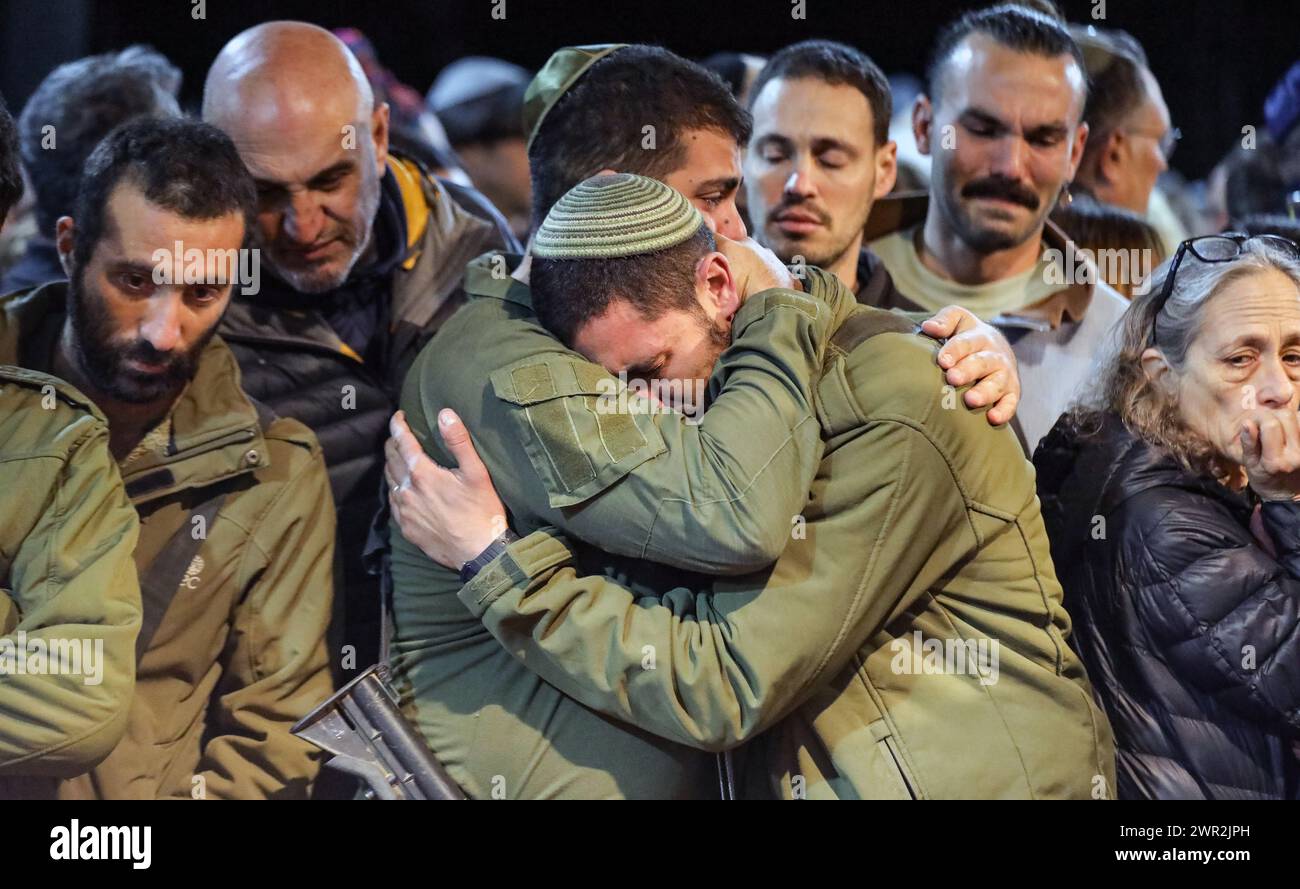 Jérusalem, Israël. 10 mars 2024. Les gens près de la tombe fraîche de Michael Gal qui a été tué dans la guerre de l'épée de fer entre Israël et le Hamas dans le regard. Au centre de la photo, il y a deux soldats, serrés l'un l'autre, pleurant. Crédit : Yoram Biberman/Alamy Live News. Banque D'Images