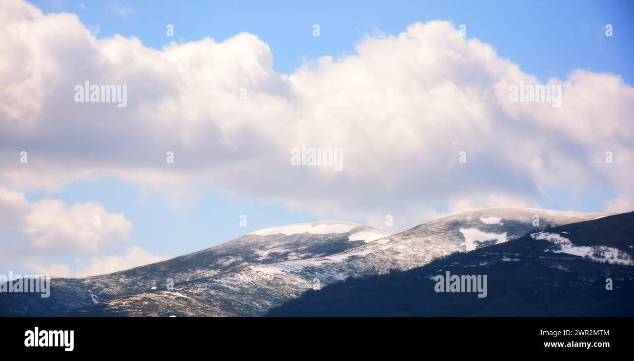 fond de nature des montagnes des carpates au printemps. paysage avec des sommets enneigés de borzhava dans la lumière du matin sous un ciel avec des nuages Banque D'Images