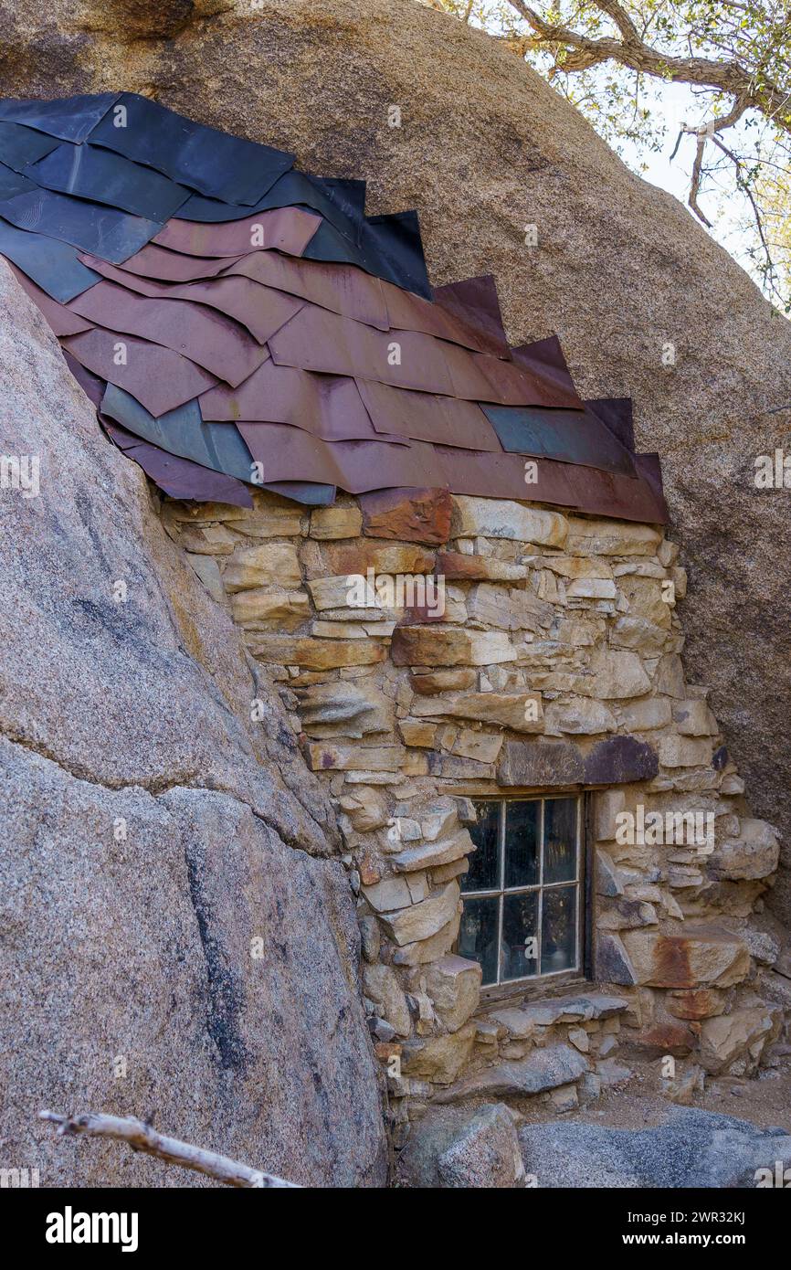 Vieille fenêtre, mur de pierre et bardeaux de toit en métal à la cabane de la mine Eagle Cliff dans le parc national Joshua Tree, Californie Banque D'Images