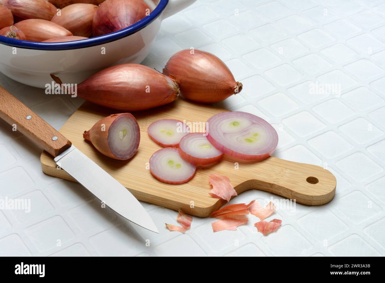 Échalotes tranchées sur une planche de bois avec un couteau, Allium cepa Banque D'Images