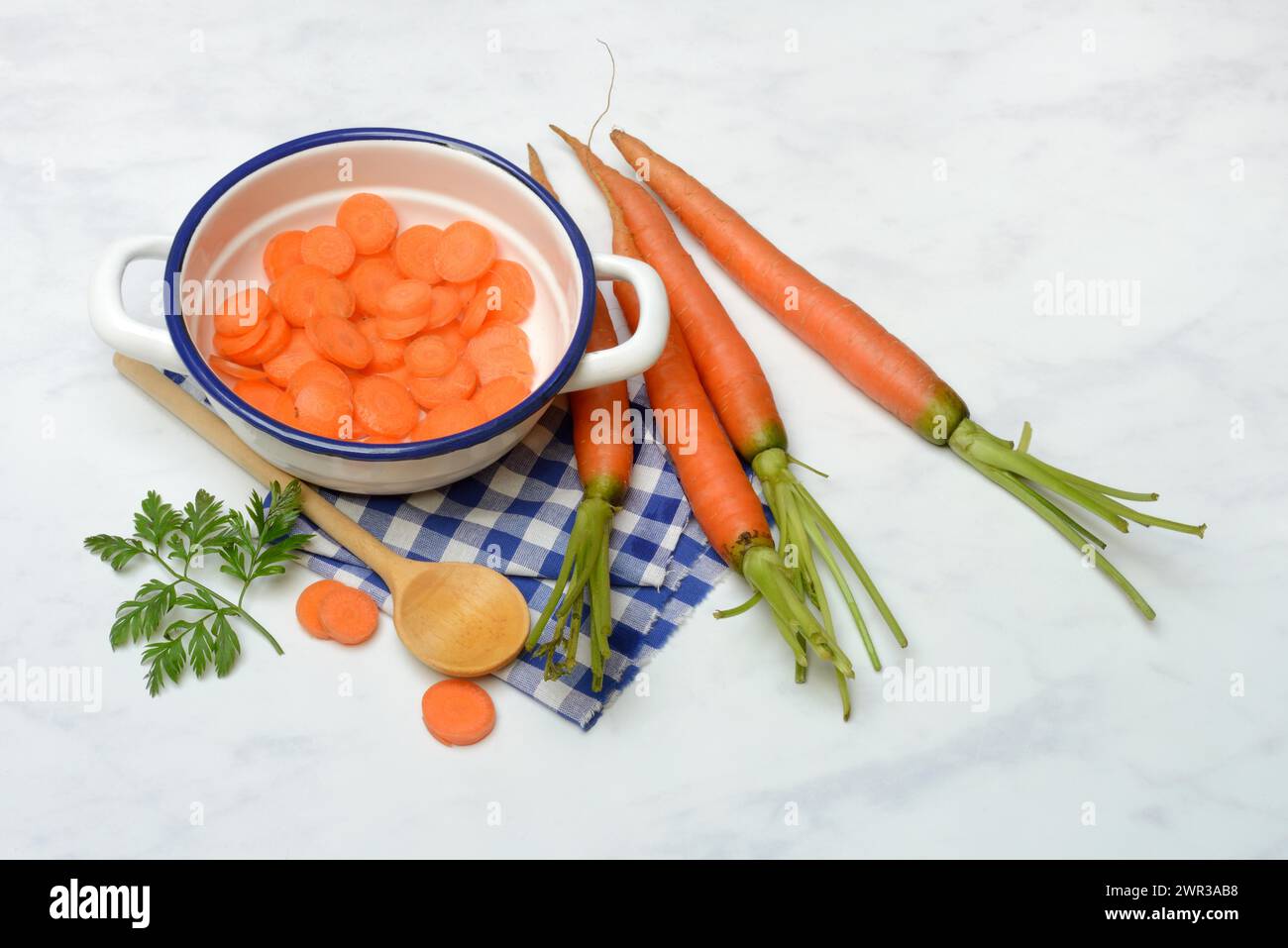 Tranches de carotte en pot et cuillère en bois, carotte (Daucus carota) Banque D'Images