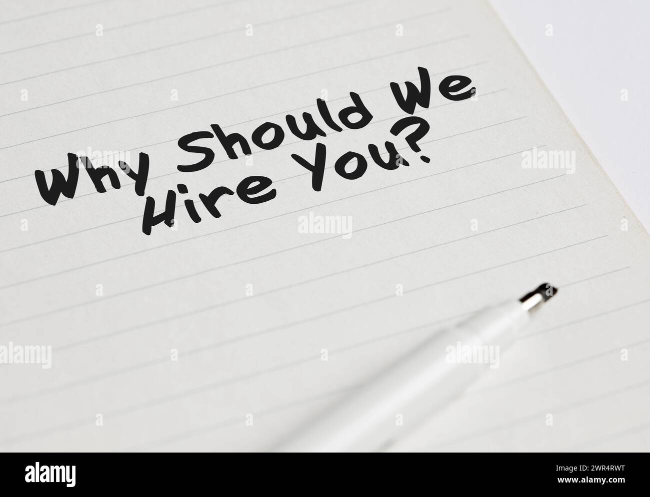 La question d'entretien d'affaires de pourquoi devrions-nous vous embaucher écrit sur un cahier avec marqueur de stylo. Banque D'Images