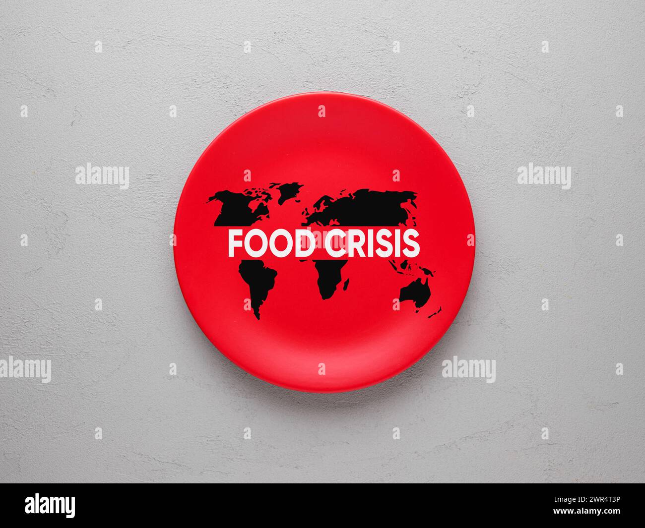 Concept de crise alimentaire mondiale. Le mot crise alimentaire avec une carte du monde sur une plaque rouge sur fond gris texturé. Banque D'Images