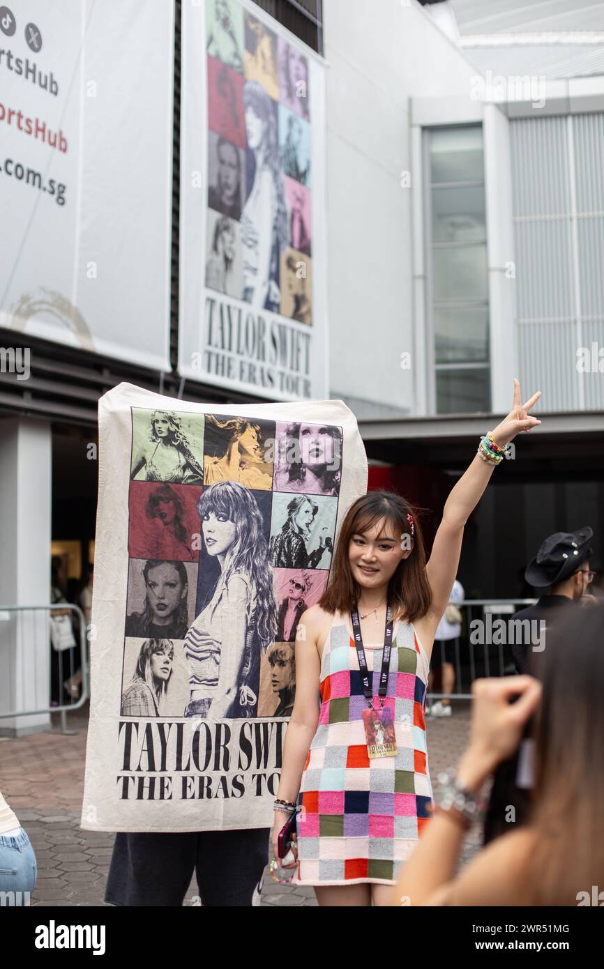 Le 9 mars 2024, les fans chinois posent avec Taylor Swift couverture graphique promotionnelle et tableau promotionnel derrière, le Eras Tour à Singapour. Banque D'Images