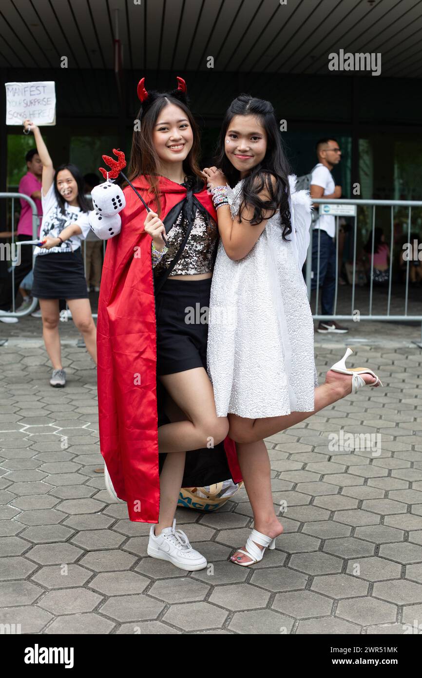 9 mars 2024, vue verticale de jolies fans féminines vêtues de costumes de diable et d'ange posent pour photo. Taylor Swift The Eras Tour à Singapour. Banque D'Images
