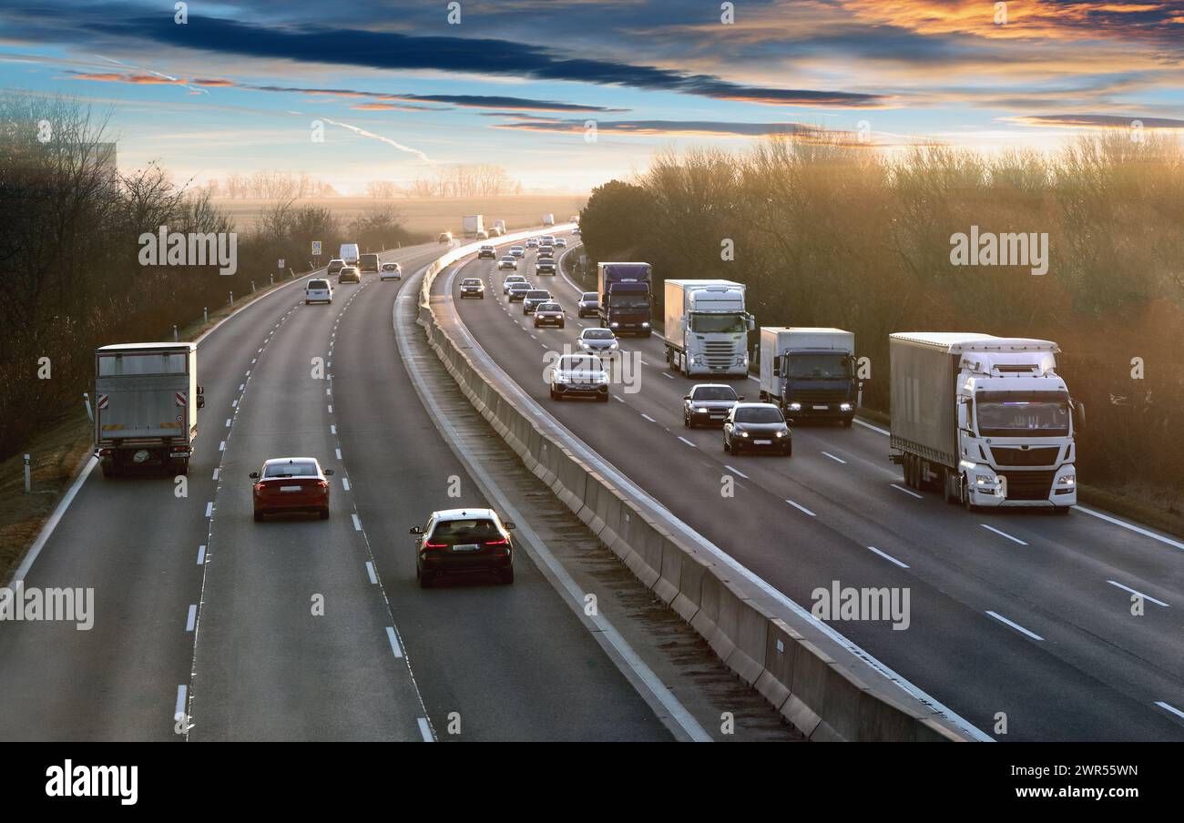 Camions de transport en conduite à grande vitesse sur une autoroute à travers le paysage rural. Scène de fret sur l'autoroute Banque D'Images