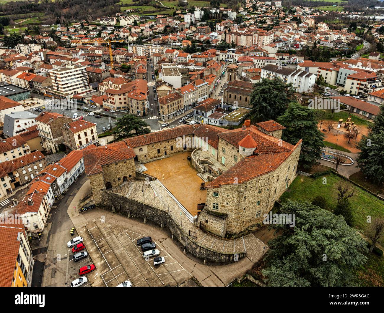 Vue aérienne des tours et remparts du château médiéval de Roche la Molière, en arrière-plan la ville moderne de Roche la Molière. France Banque D'Images