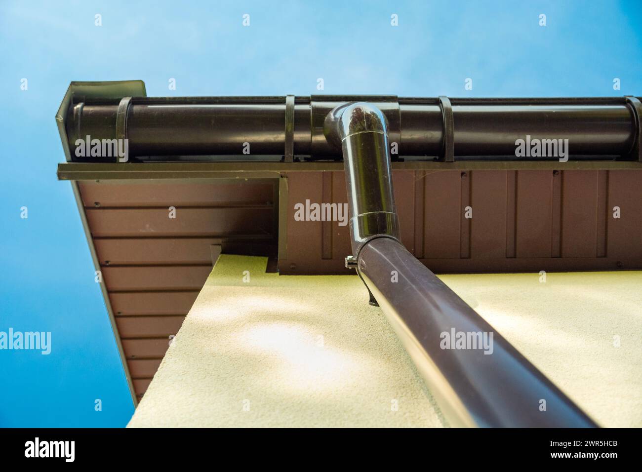 Tuyau de descente en plastique depuis la gouttière du toit, vue de dessous Banque D'Images