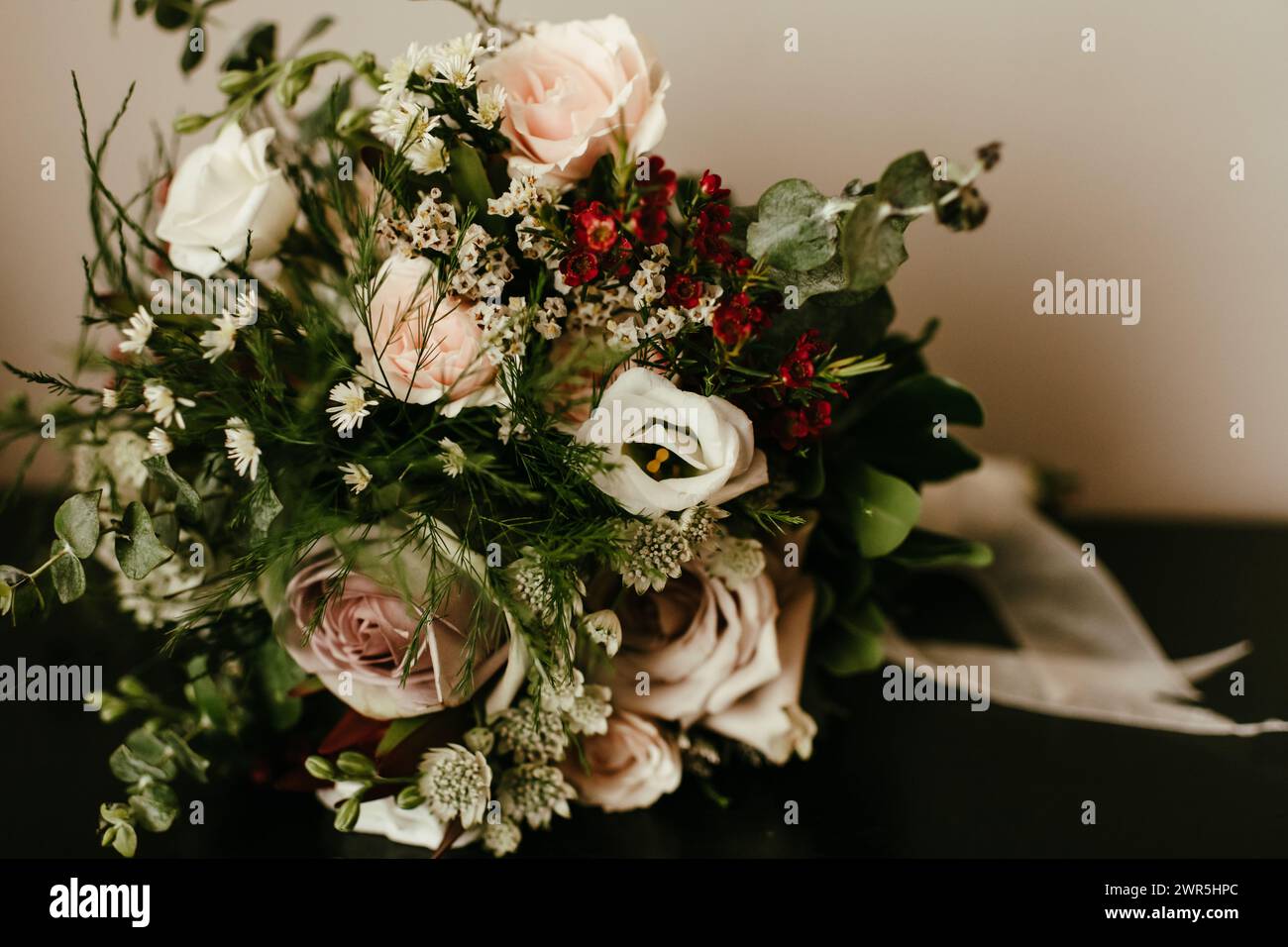 Bouquet moderne avec des danses, des roses et de l'eucalyptus couché sur une table noire Banque D'Images