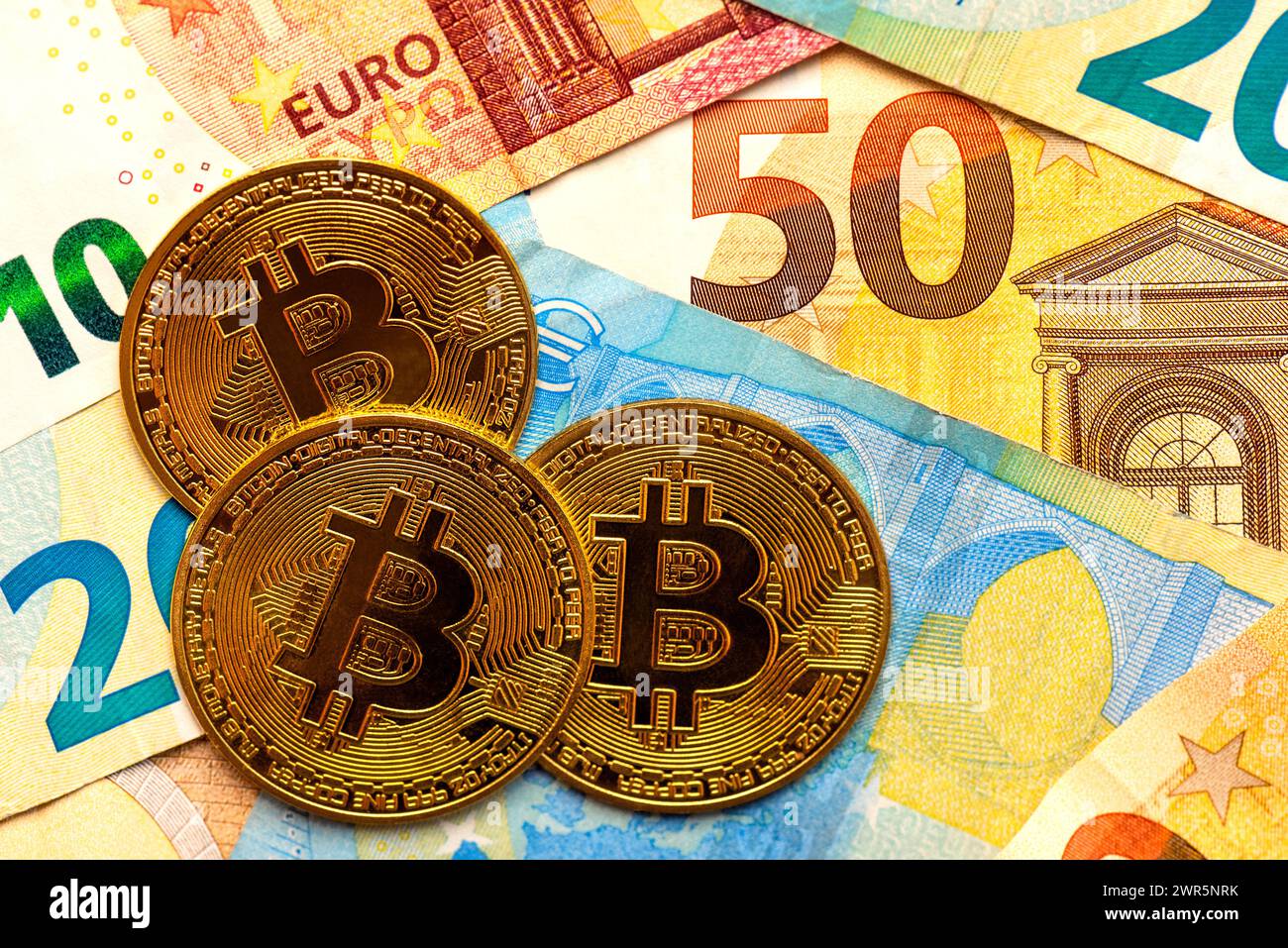 Gros plan de la pièce de monnaie bitcoin en or avec des billets en euros. Crypto-monnaie électronique Banque D'Images
