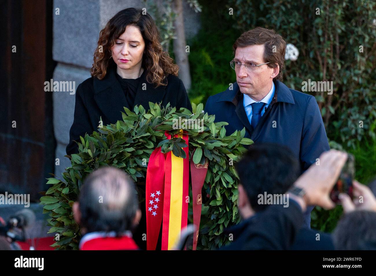 Isabel Diaz Ayuso (à gauche), présidente de la Communauté de Madrid et figure de proue du PP, et Jose Luis Martinez Almeida (à droite), maire de Madrid, ont vu tenir une couronne funéraire lors de la célébration du vingtième anniversaire des attentats terroristes du 11M. Le matin du 11 mars 2004 (également connu en Espagne sous le nom de 11M), une série de bombardements simultanés ont eu lieu contre le système de trains de banlieue Cercan'as de Madrid. Les explosions ont tué 193 personnes et en ont blessé environ 2 050. Les attaques ont été menées par des terroristes individuels qui s'opposaient à l'implication espagnole dans les 2003 États-Unis. Banque D'Images