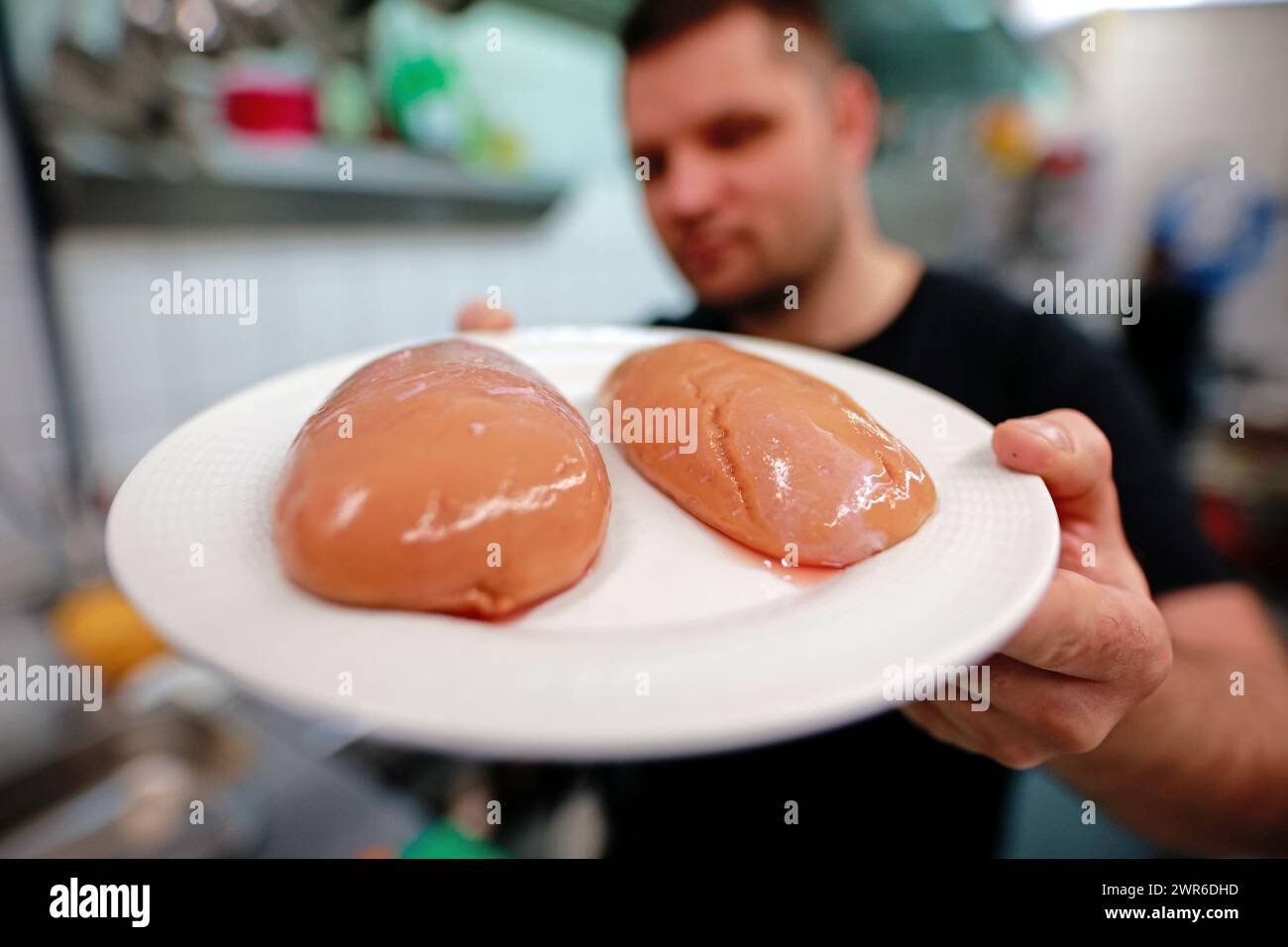 Tanne, Allemagne. 11 mars 2024. Le chef Timo Leisdorf prépare des testicules de taureau frais pour un plat au restaurant Brockenbauer à Tanne. La nouvelle délicatesse sera bientôt ajoutée au menu du restaurant. Brockenbauer Thielecke à Tanne commercialise près de 100 % de ses bovins. Avec les testicules de taureau, ils ont créé une spécialité inhabituelle qui est à servir comme huîtres de montagne. Crédit : Matthias Bein/dpa/Alamy Live News Banque D'Images