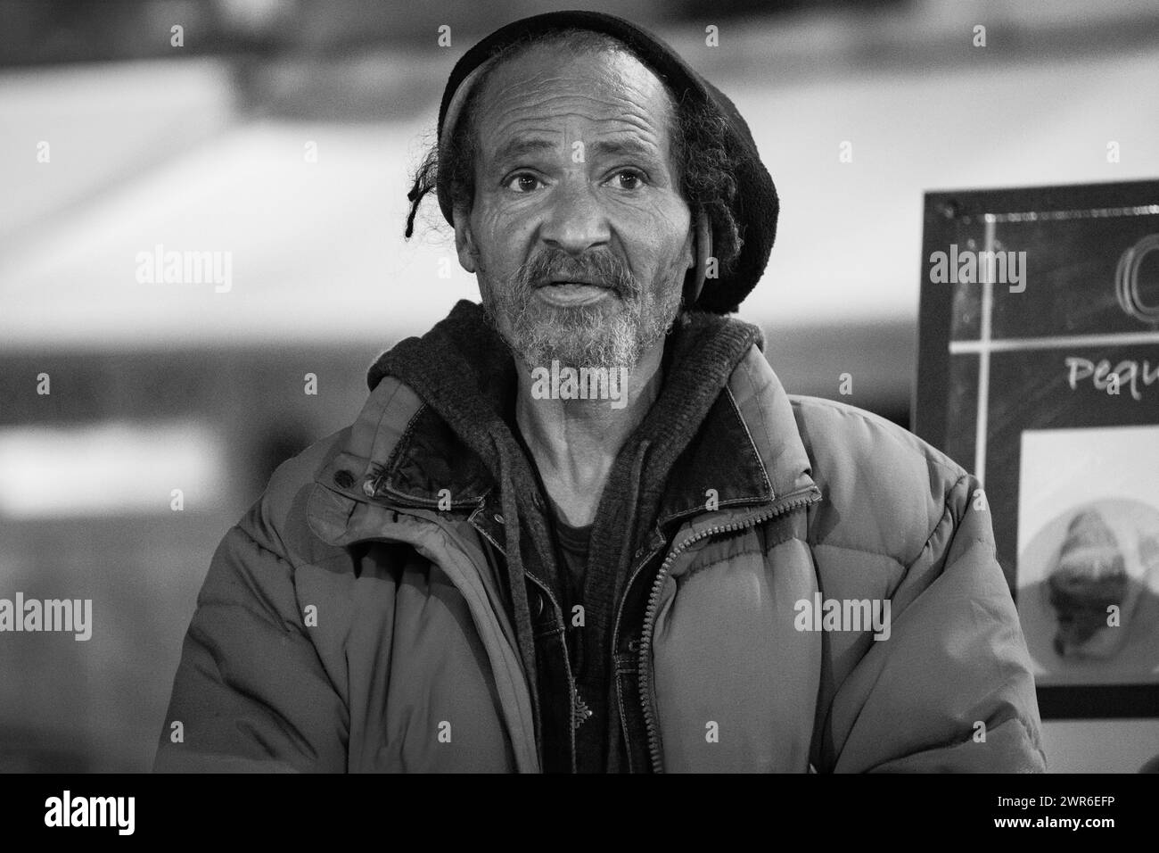 Un rastafarien âgé sans toit est assis au bar, exsudant sagesse et résilience au milieu de l'adversité. Banque D'Images