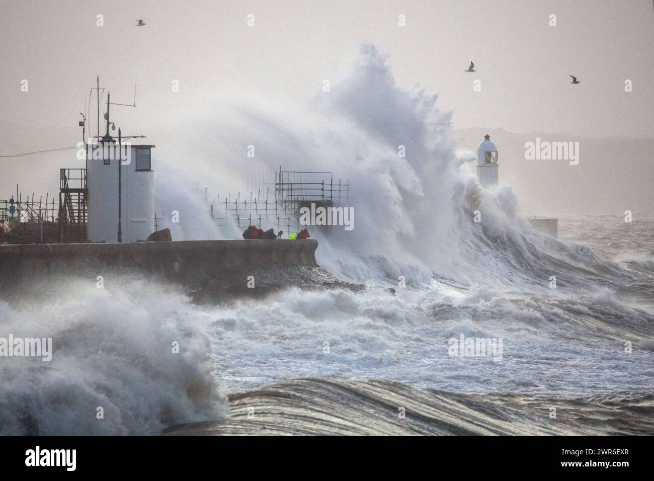 18/02/22 les photographes bravent d'énormes vagues qui s'écrasent sur le phare de 30 pieds de haut et le brise-lames du port, à Porthcawl, dans le sud du pays de Galles sous le nom de Storm Eunice Banque D'Images