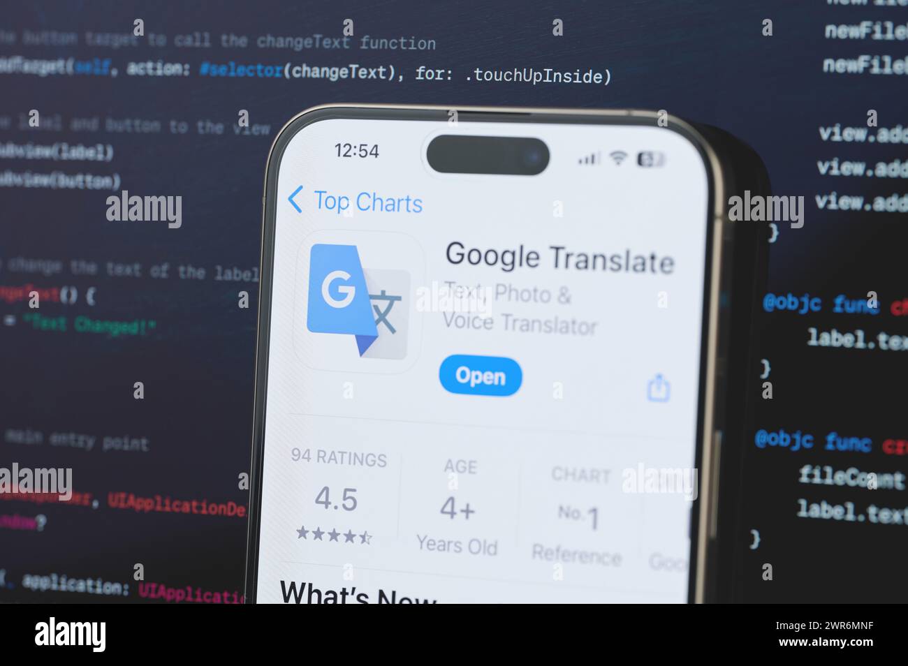 New York, États-Unis - 23 février 2024 : Google traduit sur l'écran de l'iphone en arrière-plan de programmation de code flou Banque D'Images