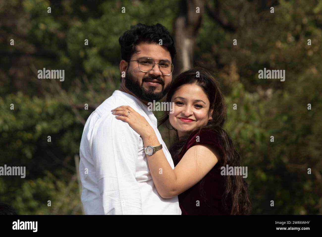 Un couple joyeux, partageant une étreinte au milieu de la beauté pittoresque de Rishikesh, regarde joyeusement dans la caméra sur fond d'arbres luxuriants, Uttarakhand Banque D'Images