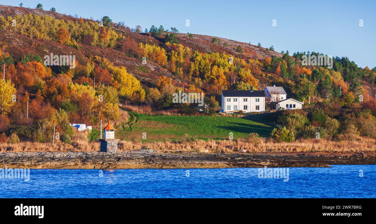 Photo panoramique de paysage norvégien. Tour de phare blanc avec sommet rouge et maisons en bois sont sur la côte rocheuse de la mer Banque D'Images