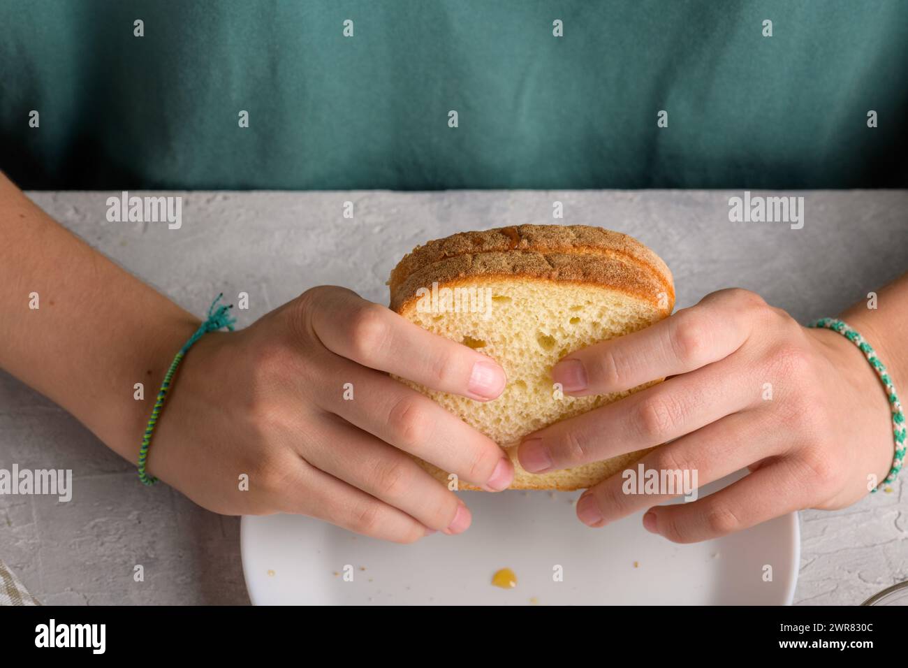 mains de femme tenant un sandwich avec du miel et du beurre d'arachide de pain de blé sur une assiette blanche, pour prendre un petit déjeuner, de près. Snack typique, nourriture lif Banque D'Images