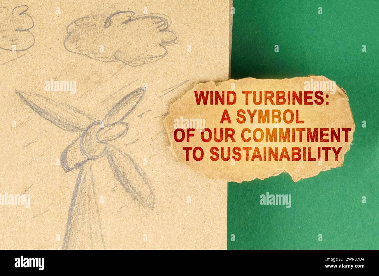Concept d'énergie alternative. Sur une surface verte, il y a un dessin avec un générateur de vent et un carton avec l'inscription - éoliennes un symbole Banque D'Images