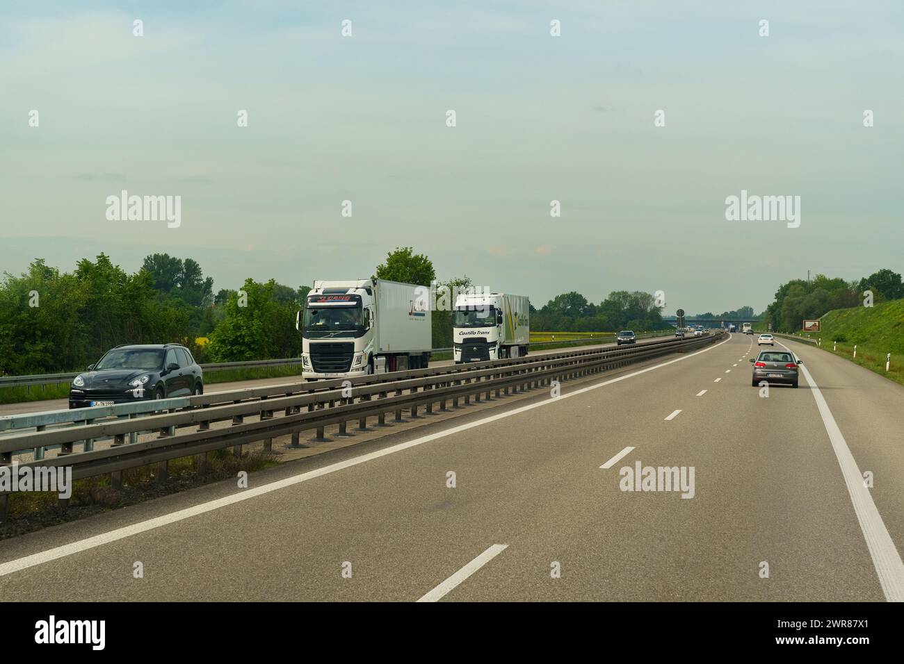 Lyon, France - 7 mai 2023 : une paire de camions se déplaçant sur une autoroute, entourée d'autres véhicules. La route s'étend au loin sous un ciel dégagé Banque D'Images