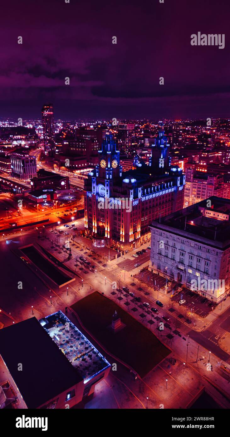 Vue aérienne nocturne d'un paysage urbain avec des bâtiments et des rues illuminés, mettant en valeur l'architecture urbaine et la vie urbaine dynamique à Liverpool, Royaume-Uni. Banque D'Images