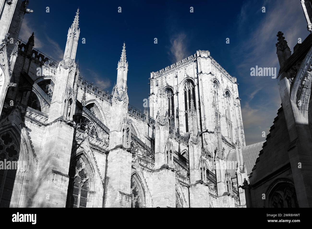 Architecture gothique de cathédrale avec des flèches contre un ciel bleu avec des nuages à York, Royaume-Uni. Banque D'Images