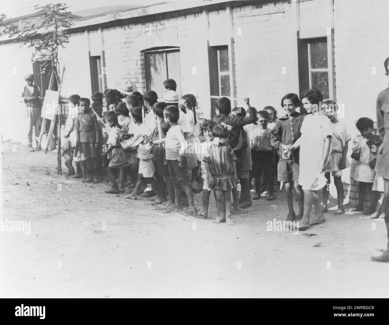 Enfants réfugiés grecs et arméniens dans des casernes près d'Athènes, la Grèce a accueilli 1 000 000 réfugiés, soit un par famille du pays, des enfants réfugiés grecs et arméniens d'Anatolie debout devant un bâtiment d'un étage., 1923., Guerre gréco-turque, 1921-1922, réfugiés, Grèce, tirages photographiques, 1920-1930., tirages photographiques, 1920-1930, 1 tirage photographique Banque D'Images