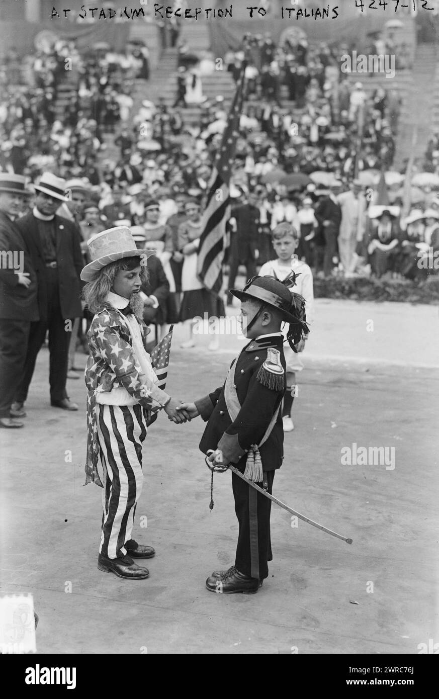 Lors de la réception des Italiens au stade, la photographie montre des enfants en costume serrant la main, lors d'une cérémonie en l'honneur du prince Ferdinando d'Udine, chef de la Commission de guerre italienne aux États-Unis, au stade de Lewisohn au Collège de la ville de New York, le 23 juin 1917. Un enfant est habillé en oncle Sam et l'autre est habillé en soldat Bersaglieri de l'armée italienne., 23 juin 1917, Guerre mondiale, 1914-1918, négatifs en verre, 1 négatif : verre Banque D'Images