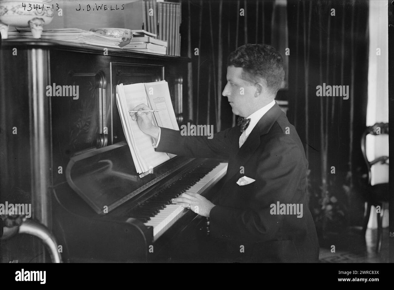 J.B. Wells, photographie montre le chanteur ténor et compositeur John Barnes Wells (1880-1935) assis à un piano., entre env. 1915 et env. 1920, négatifs en verre, 1 négatif : verre Banque D'Images