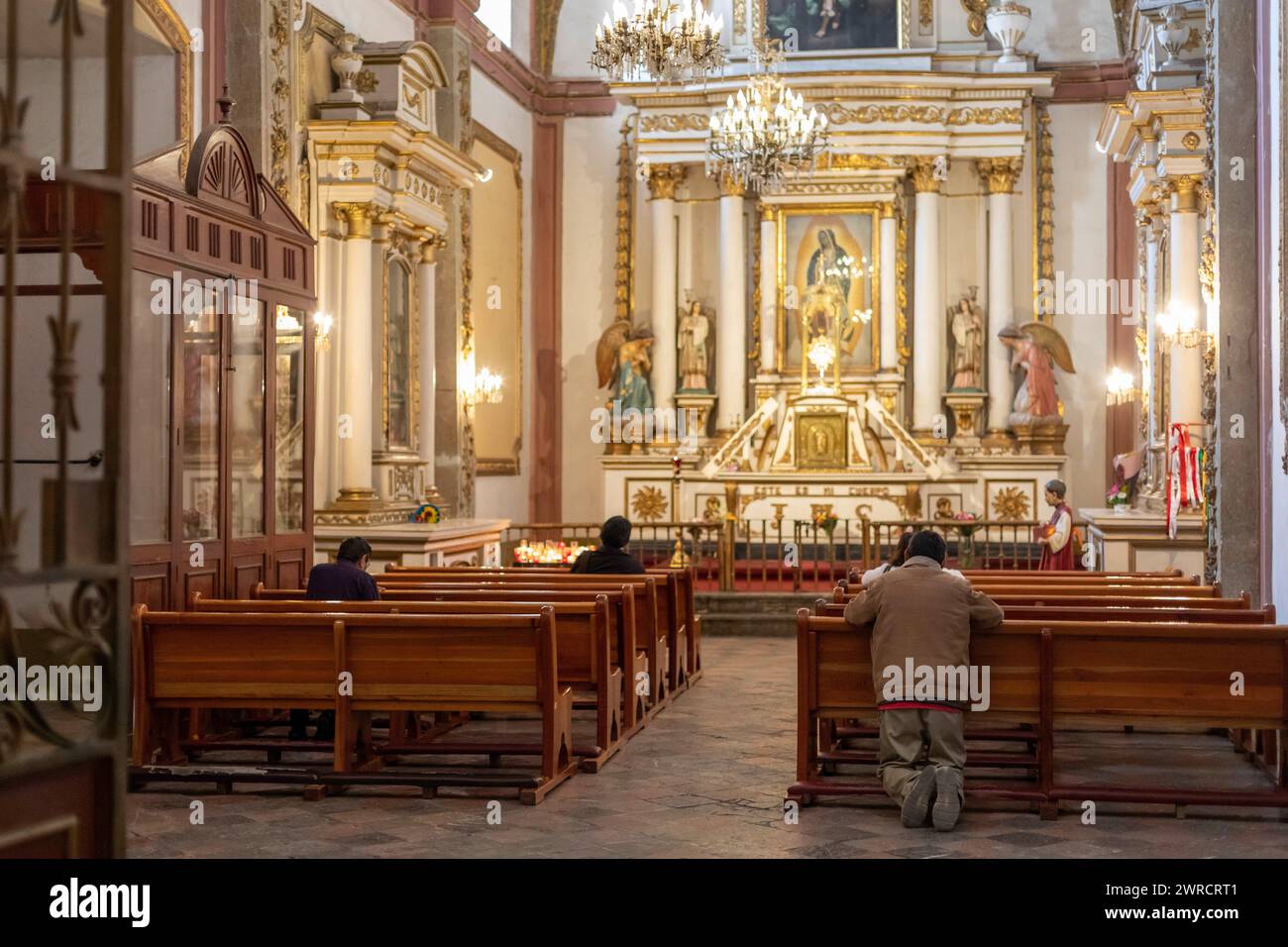 Oaxaca, Mexique - Un homme s'agenouille en prière dans une église catholique. Banque D'Images