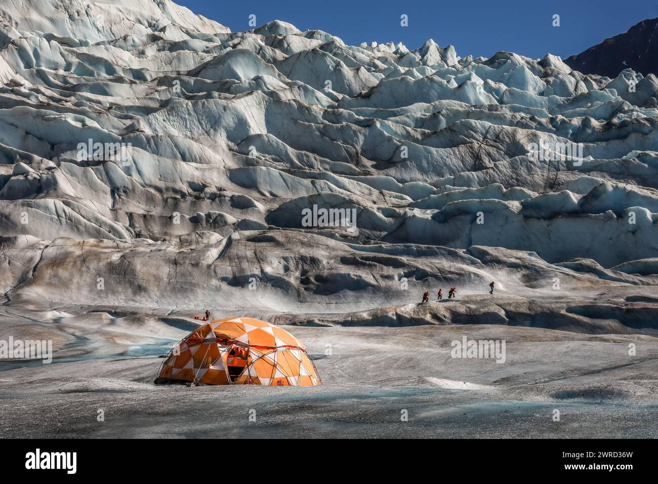 Vue imprenable sur un glacier en Alaska avec une tente et des randonneurs Banque D'Images