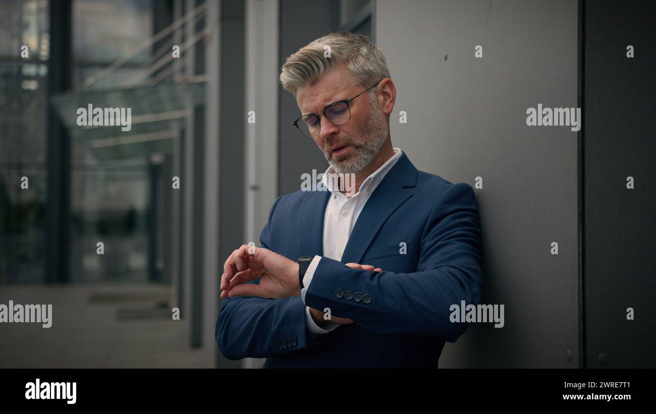 Vieil homme caucasien senior employeur masculin mature homme d'affaires d'âge moyen entrepreneur d'affaires dans la ville penchant pour le bâtiment de l'entreprise de bureau de mur mis sur Banque D'Images