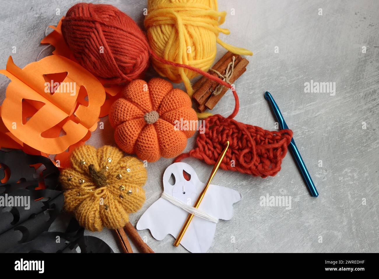 Composition de pose plate avec accessoires de tricot sur fond gris. Décorations faites à la main pour Halloween. Espace pour le texte. Banque D'Images
