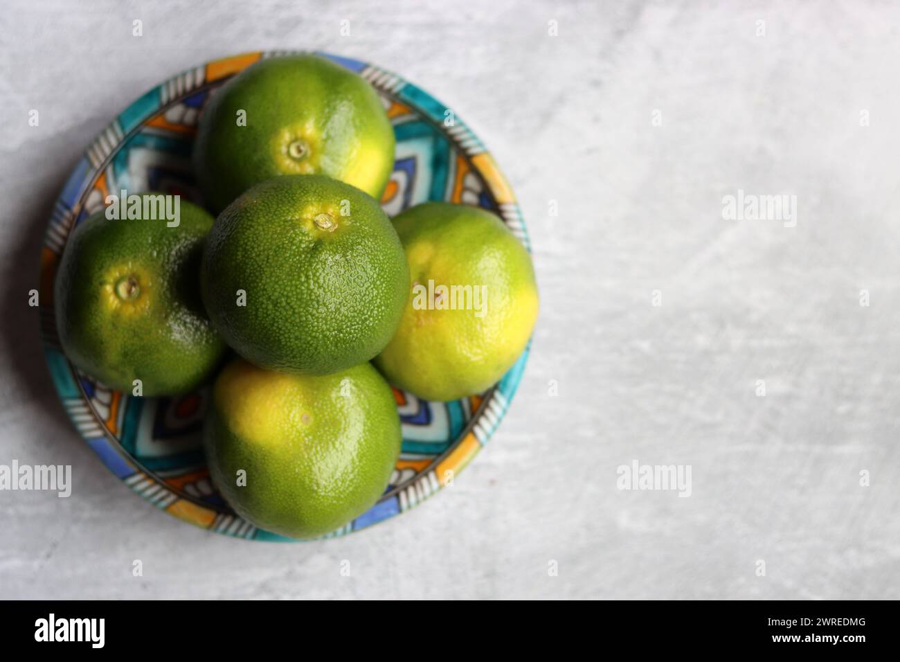 Mandarines vertes sur une plaque en céramique. Gros plan photo d'agrumes frais. Manger un concept frais. Banque D'Images