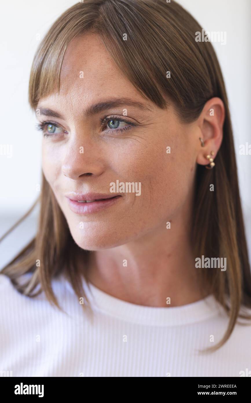 Femme caucasienne avec les cheveux brun clair et les yeux verts regarde sur le côté Banque D'Images