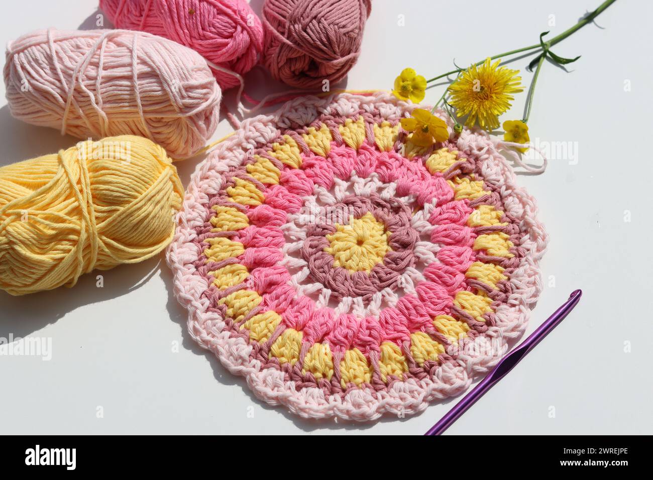 Photo vue de dessus de boules de fil de coton, crochet crochet et fleurs. Elément décoratif fait à la main. Banque D'Images