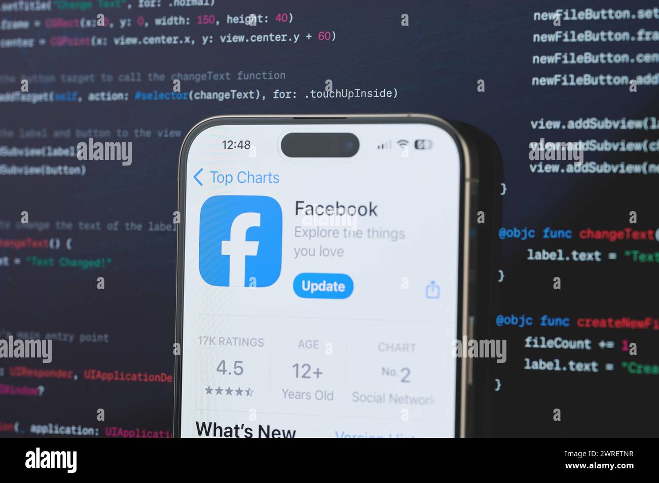 New York, USA - 23 février 2024 : Facebook sur l'écran de l'iphone en arrière-plan de programmation de code flou Banque D'Images