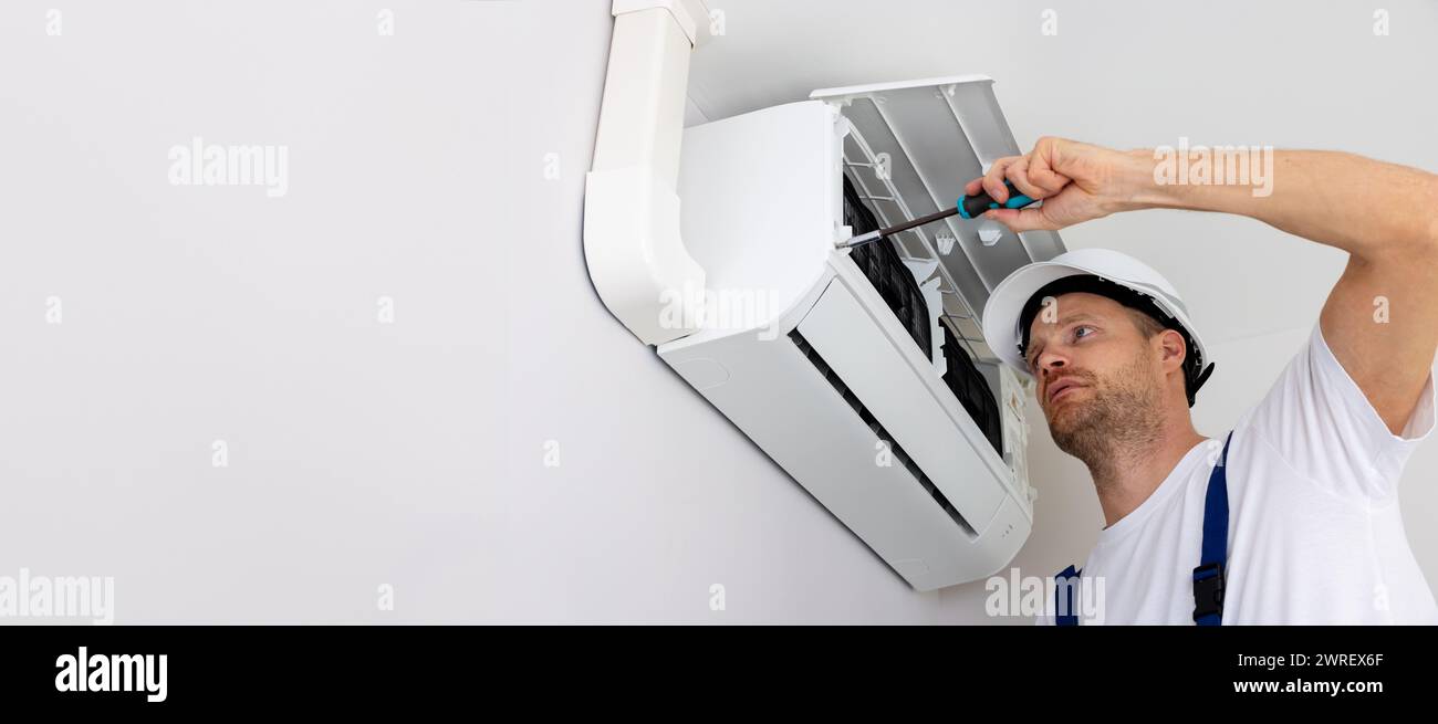 services hvac - technicien installant un climatiseur sur le mur à la maison. bannière avec espace de copie Banque D'Images