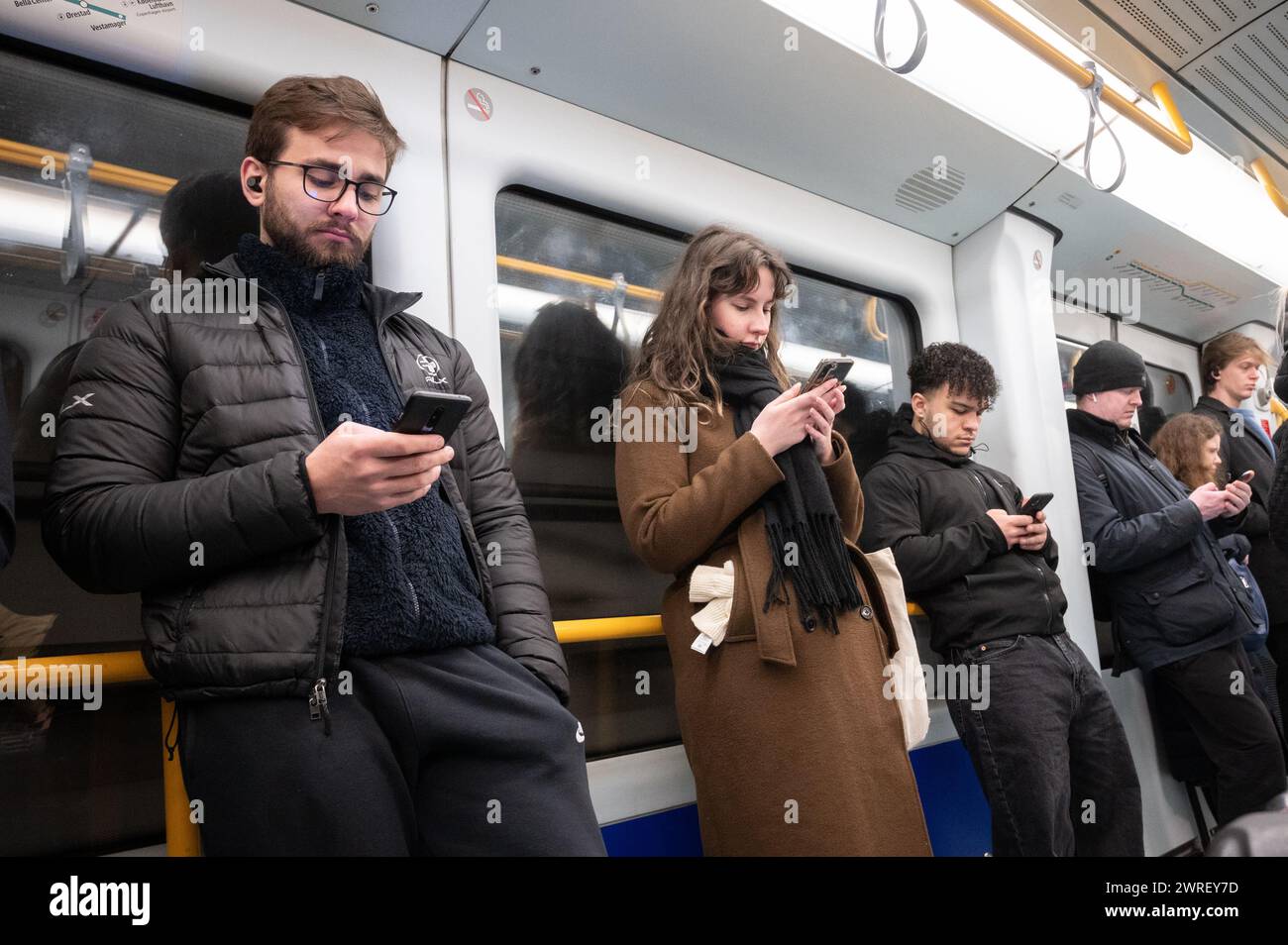 Voyageurs utilisant un téléphone portable dans le métro de Copenhague Banque D'Images