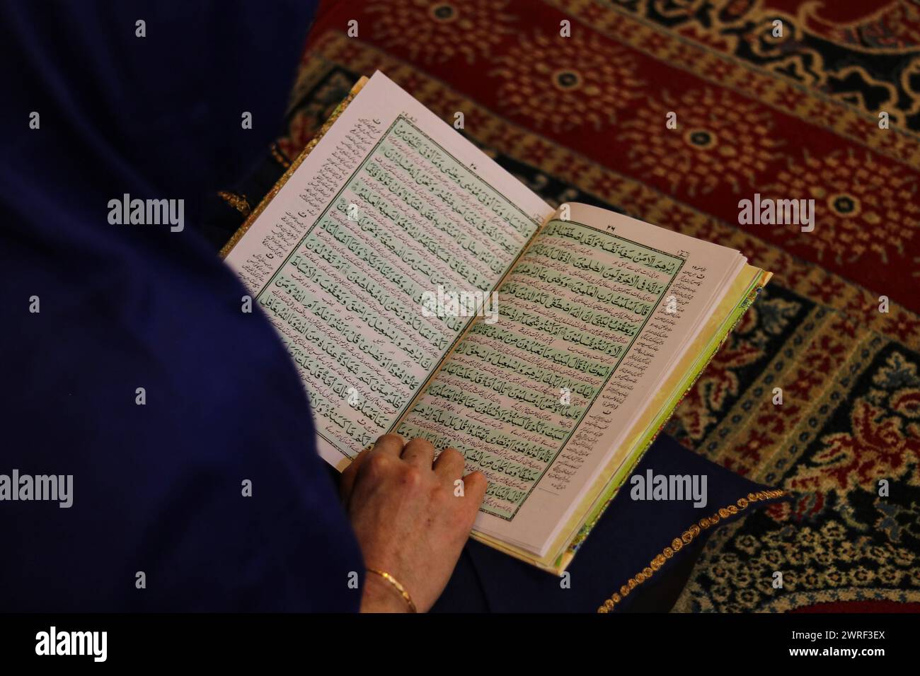 Srinagar, Inde. 12 mars 2024. 12 mars 2024, Srinagar Cachemire, Inde : Une femme récite du Saint Coran à l'intérieur d'un sanctuaire le premier jour du Ramadan à la Grande Mosquée (Jamia Masjid) de la vieille ville de Srinagar. Les musulmans du Cachemire se lancent dans un voyage de jeûne d'un mois. Le 12 mars 2024, Srinagar Cachemire, Inde. (Photo de Firdous Nazir/Eyepix Group) crédit : Sipa USA/Alamy Live News Banque D'Images