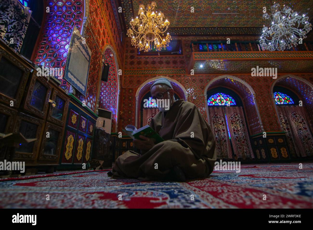 Srinagar Cachemire, Inde. 12 mars 2024. Un homme récite du Saint Coran à l'intérieur d'un sanctuaire le premier jour du Ramadan à la Grande Mosquée (Jamia Masjid) de la vieille ville de Srinagar. Les musulmans du Cachemire se lancent dans un voyage de jeûne d'un mois. Le 12 mars 2024, Srinagar Cachemire, Inde. (Crédit image : © Firdous Nazir/eyepix via ZUMA Press Wire) USAGE ÉDITORIAL SEULEMENT! Non destiné à UN USAGE commercial ! Banque D'Images