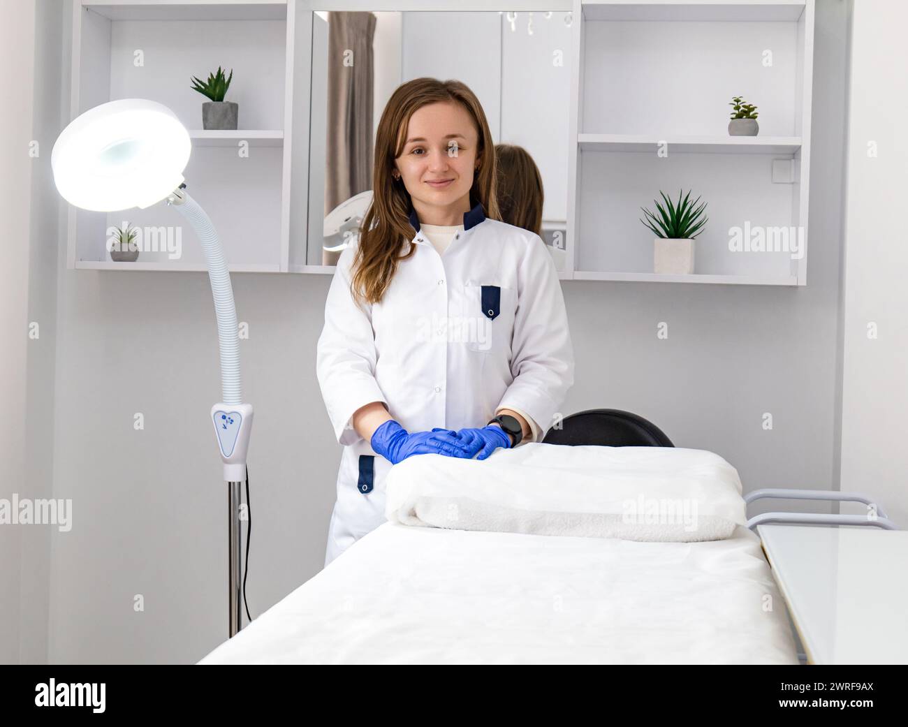 Femme cosmétologue debout et regardant la caméra dans le salon de spa de beauté. Dermatologue féminine, thérapeute de la peau, esthéticienne professionnelle de soins de la peau en Clea Banque D'Images