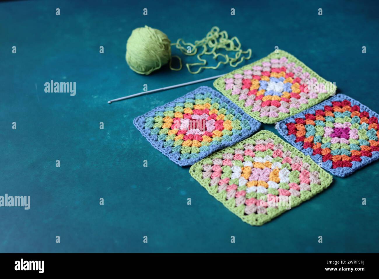 Projet de crochet en fabrication. Carrés au crochet colorés gros plan photo. Haut fabriqué à la main en cours de traitement. Banque D'Images