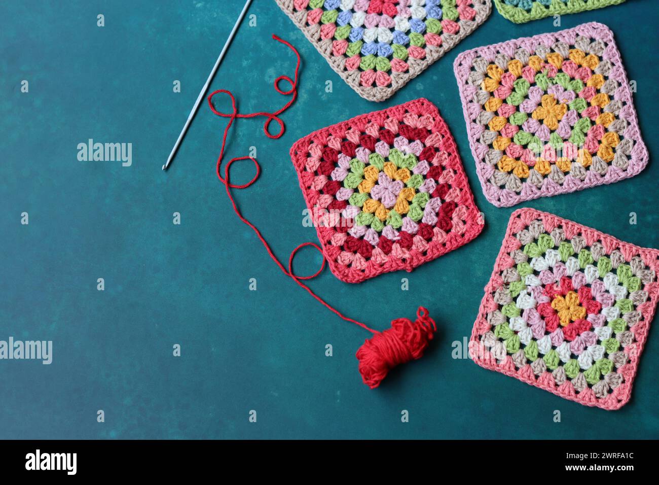 Projet de crochet en fabrication. Carrés au crochet colorés gros plan photo. Haut fabriqué à la main en cours de traitement. Banque D'Images