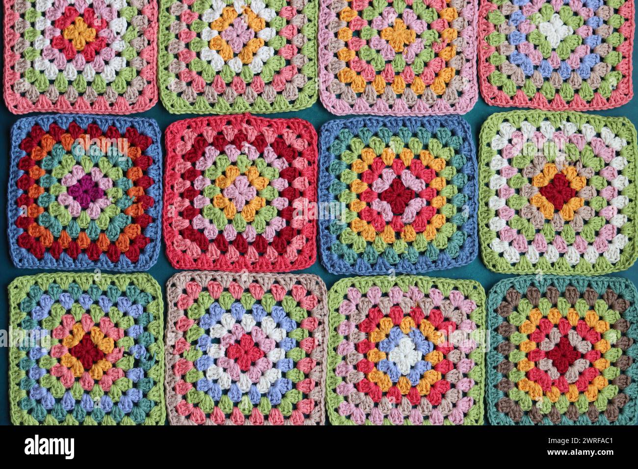 Projet de crochet en fabrication. Carrés au crochet colorés gros plan photo. Haut fabriqué à la main en cours de traitement. Banque D'Images