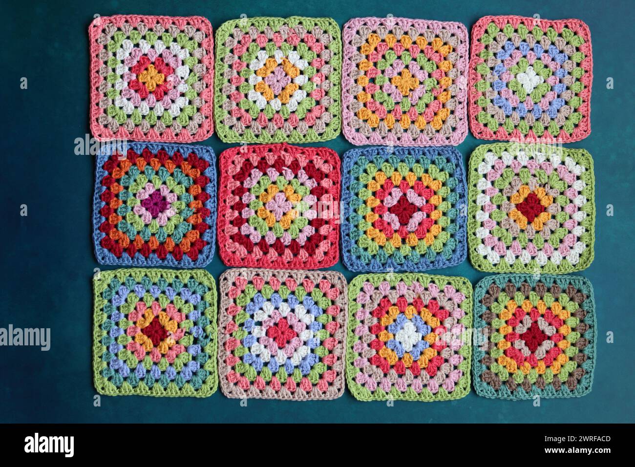 Projet de crochet en fabrication. Carrés au crochet colorés gros plan photo. Haut fabriqué à la main en cours de traitement. Banque D'Images