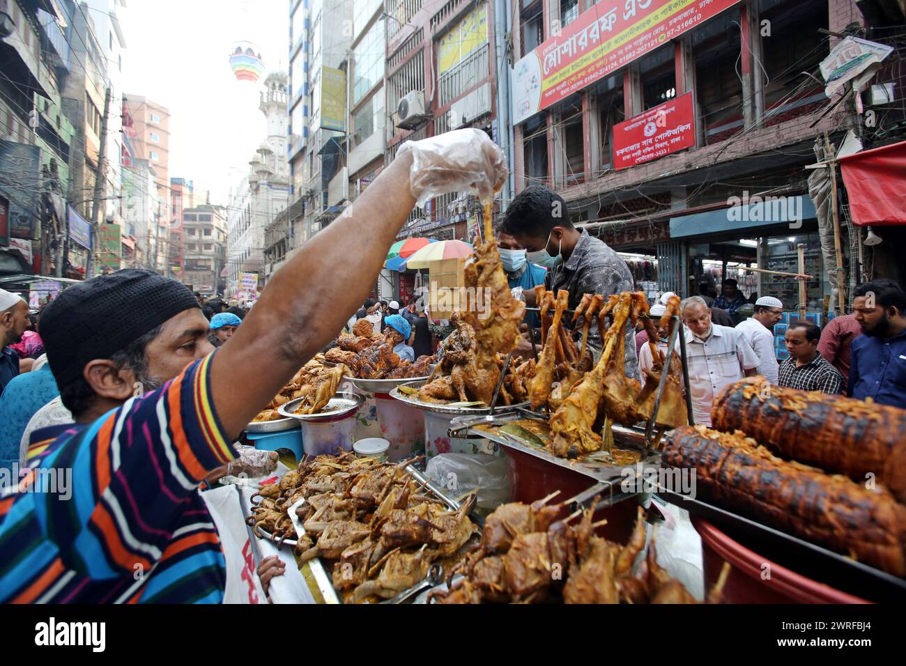 Les musulmans bangladais achètent de la nourriture pour rompre leur jeûne pendant le premier jour du mois de jeûne du Ramadan sur un marché alimentaire traditionnel au bazar de Chalk, à Dhaka, au Bangladesh, le 12 mars 2024. Le mois sacré du Ramadan pour les musulmans est le neuvième mois du calendrier islamique, et on croit que la révélation du premier verset du Coran a eu lieu au cours de ses 10 dernières nuits. C’est aussi un moment de socialisation, principalement le soir après avoir rompu le jeûne, et un déplacement de toutes les activités vers la fin de la journée dans la plupart des pays. Photo Habibur Rahman/ABACAPRESS.COM Banque D'Images