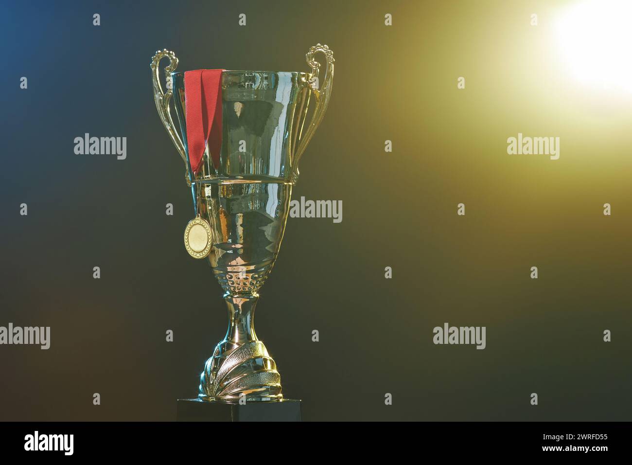Image de fond de coupe de trophée d'or et médaille avec ruban rouge sur fond noir avec espace de copie d'effet de lumière Banque D'Images