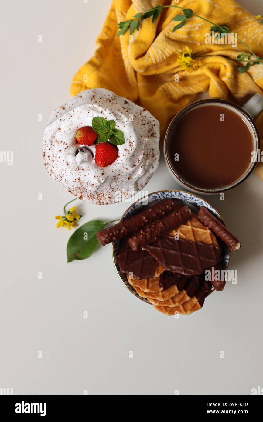 Photo vue de dessus de tasse de thé au lait, gaufres et biscuits dans un bol. Nourriture sucrée gros plan photo. Fond blanc avec espace pour le texte. Banque D'Images