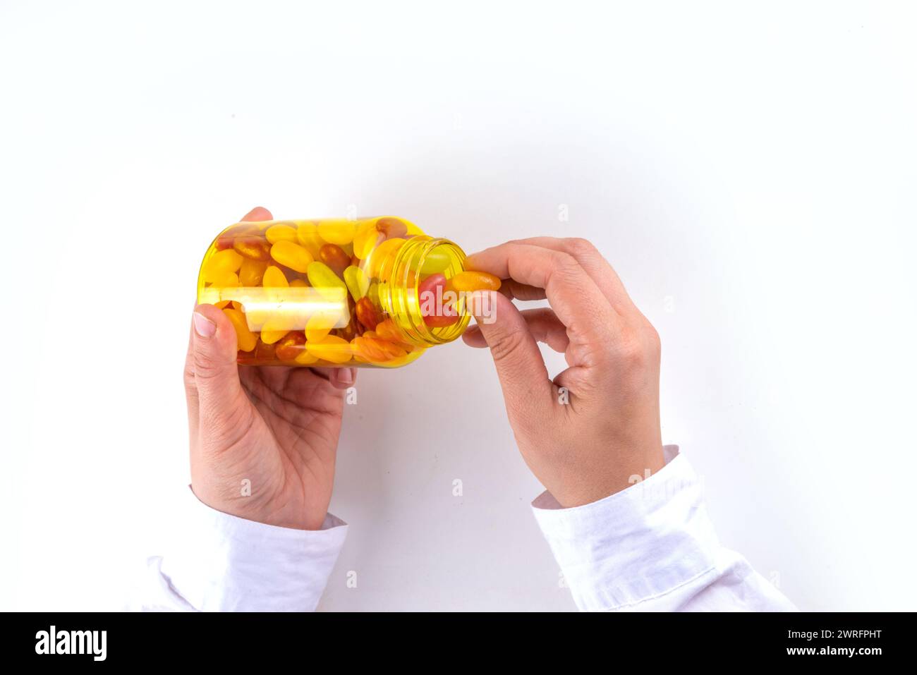 Vitamines Gummy et supplément pour adultes. La femme mange des micro-éléments de bonbons multivitaminés de gelée sucrée à partir de bouteilles de pilules transparentes, de médicaments modernes et Banque D'Images